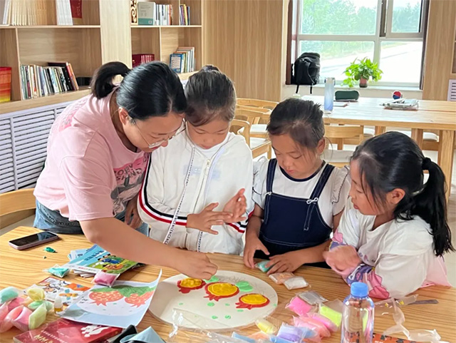 伊金霍洛鎮(zhèn)青年志愿者在暑托班中開展  黏土畫制作活動(dòng)。